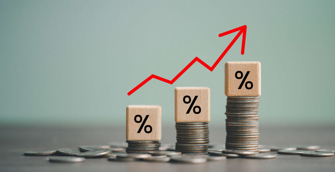 inflation concept, red graph arrow, Percent sign on a wooden cube with row of coins in idea for FED consider interest rate hike, world economics, and inflation control, US dollar inflation.