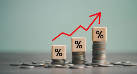 inflation concept, red graph arrow, Percent sign on a wooden cube with row of coins in idea for FED consider interest rate hike, world economics, and inflation control, US dollar inflation.